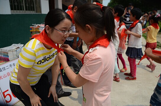 捐贈(zèng)儀式上，孩子們?yōu)閻坌奶焓瓜瞪霞t領(lǐng)巾