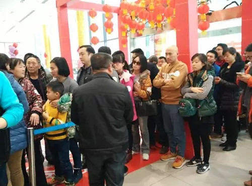 排隊(duì)領(lǐng)年貨，一家老小齊上陣。