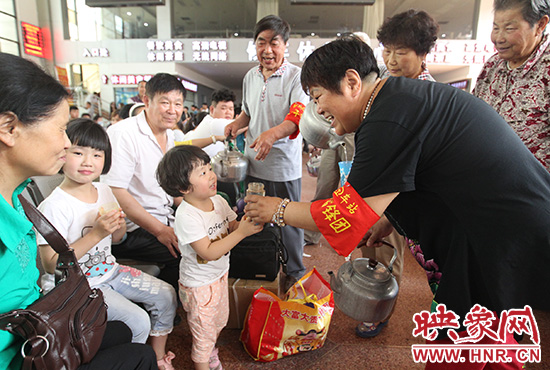 老年雷鋒團(tuán)”志愿者在候車廳為旅客送水。