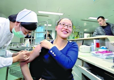 昨日，向雪敏在同濟醫(yī)院血液科病房打動員劑，丈夫陳武右在身后注視著妻子 記者傅克強