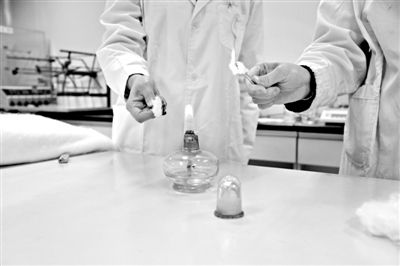 實驗人員操作的燃燒檢測法中，真蠶絲離開火焰就熄滅(左)。