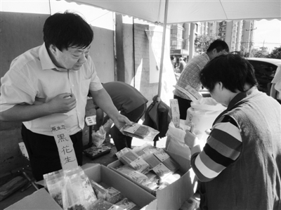 昨日，河南企業(yè)家劉春喜在京“練攤”，為顧客挑選綠豆。新京報記者 張玉學(xué) 攝