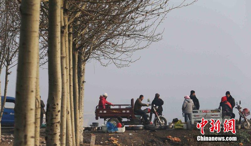 圖為12月1日，104國(guó)道靜海縣城附近，104國(guó)道靜?？h城附近，高速旁邊形成的黑市。田寶希 攝 圖片