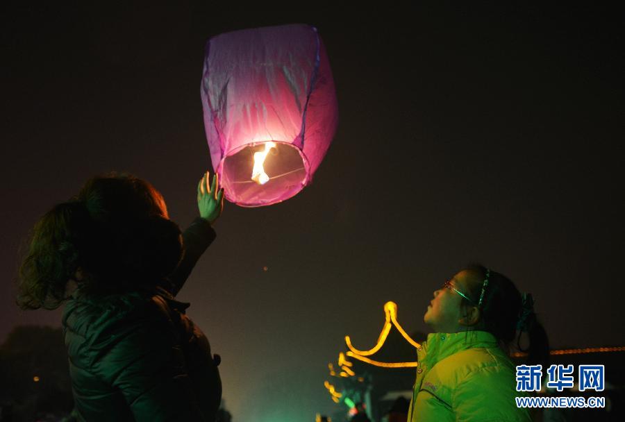 　1月30日，游客在江蘇省鎮(zhèn)江市金山公園門口放飛孔明燈。