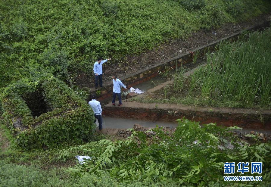 5月18日，工作人員在槽罐車泄漏現(xiàn)場(chǎng)附近的水渠邊查看情況。