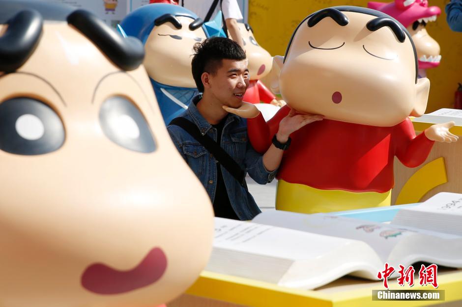 4月22日，游客與蠟筆小新合影?！跋灩P小新25周年紀念特展”日前在北京開展，吸引了不少市民游客。