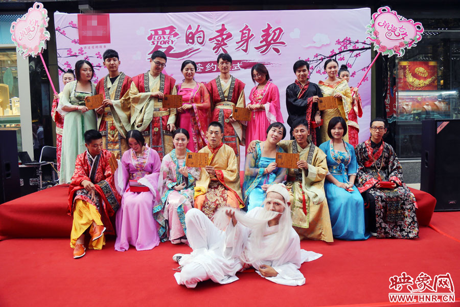 現(xiàn)場8對兒年輕男女舉起“賣身契”集體拍照。