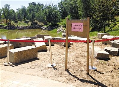 圓明園規(guī)月橋橋體構(gòu)件區(qū)域的警戒線和提示牌。 新京報(bào)記者 鄧琦 攝