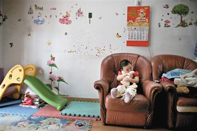 6月14日，未婚媽媽于軍的家里。女兒悅悅抱著兔子玩偶，在聽媽媽手機上的兒歌，這個4歲女孩喜歡兔子。