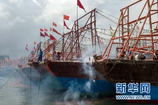 2013年8月1日 南海開漁日 臨高迎新港 8月1日，海南省臨高縣漁民在船上鳴放鞭炮慶祝武蓮港開港。
