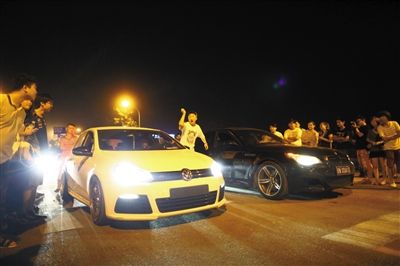8月24日晚，東壩中街飆車現(xiàn)場(chǎng)，兩輛車并排等待出發(fā)指令，旁邊許多愛(ài)好者前來(lái)觀看比賽。新京報(bào)記者
