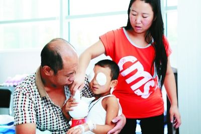 斌斌手術(shù)后第一天恢復(fù)良好，斌斌父母在用玩具逗他開心供圖/嚴益