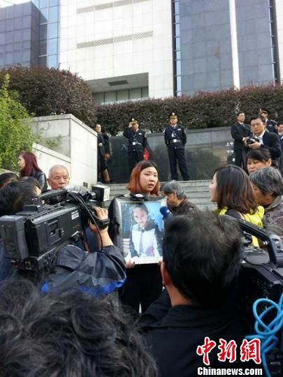 法院外，死者祁某的家人正在接受媒體采訪。 田雯 攝