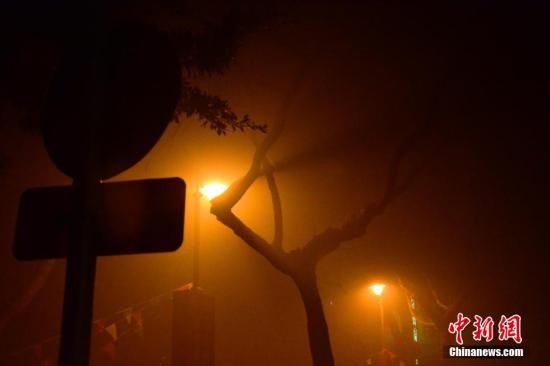 1月31日凌晨，市民行走在煙霧繚繞的南京街頭。當(dāng)天是農(nóng)歷馬年正月初一，南京有限開禁燃放煙花爆竹正逢下霧天，空氣的不流通致使煙花爆竹燃燒后產(chǎn)生的顆粒物不能及時散開，造成整座城市煙霧繚繞。據(jù)當(dāng)?shù)丨h(huán)保部門發(fā)布的信息顯示，空氣質(zhì)量屬重度污染。中新社發(fā) 泱波 攝