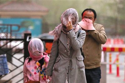 昨日下午，朝陽(yáng)區(qū)豆各莊，行人將紗巾裹在頭上防沙塵。