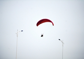 10月25日下午，動力傘從一對路燈上空飛過