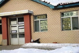 伊春市帶嶺區(qū)一排破舊的平房，房間窗戶上貼滿了“我告饒了”的字樣。