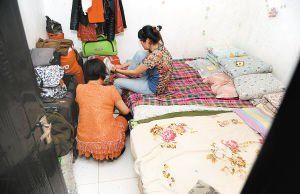 在米家崖一民房?jī)?nèi)，母親蹲在地上幫身陷傳銷的女兒穿鞋，但遭到女兒拒絕