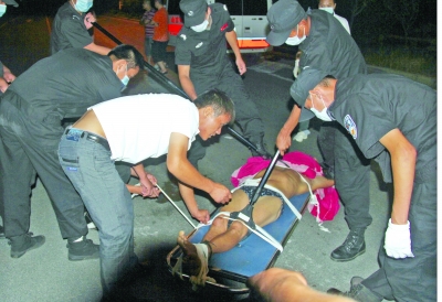 眾人合力將狂犬病發(fā)作的江某控制住。 孫東城 攝