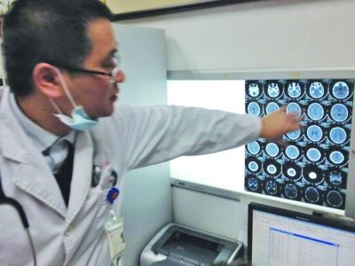 醫(yī)生在查看男孩的腦部CT片。薛馬義 攝