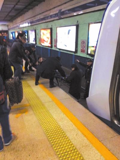 地鐵工作人員將林某從站臺下救起。網(wǎng)友供圖