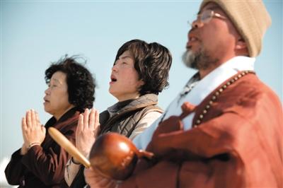 23日，一名僧侶引領(lǐng)人們?yōu)樗勒咂矶\。