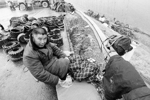 　出事司機(jī)的鞋找不到了，只好用塑料袋套著腳取暖