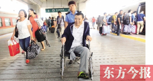 李剛手術(shù)后歸來，在車站工作人員幫助下走出鄭州火車站站臺  東方今報首席記者 張曉冬 攝