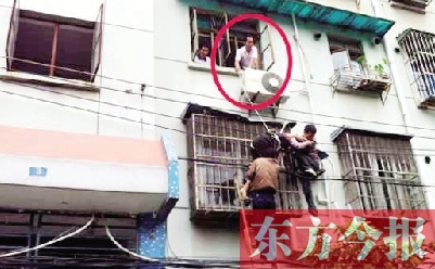 施救現(xiàn)場，劉鵬（圈內(nèi)）先用繩子捆住老太確保安全 勞動報記者 郭娜 供圖