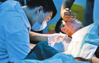 孩子身上有7道傷痕，其中兩道需要縫合，其他的均為擦傷，醫(yī)生正對他施治。