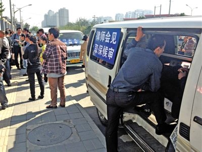 昨日，朝陽區(qū)看守所門前有人排隊。大門外還停有多輛寫有“律師會見”字樣的車。