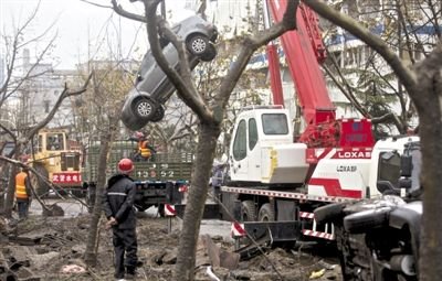 輸油管道爆炸后，搶修人員將被炸毀的車輛運出現(xiàn)場。