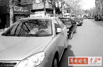 友愛路，路邊停了一排車，本來(lái)不寬的路就變得更窄了。