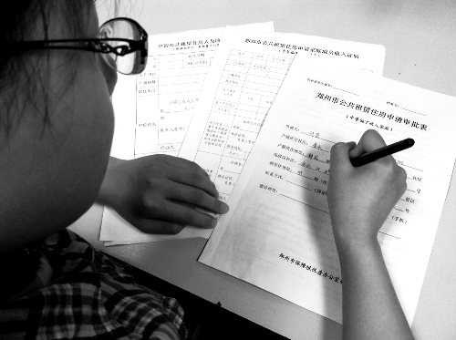 一位女士在填寫公租房申請(qǐng)審批表 一位女士在填寫公租房申請(qǐng)審批表