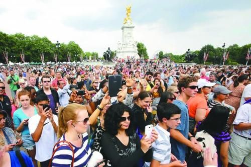 7月23日，在英國倫敦白金漢宮外，民眾們爭相閱讀“王室寶寶”出生的正式公告。
