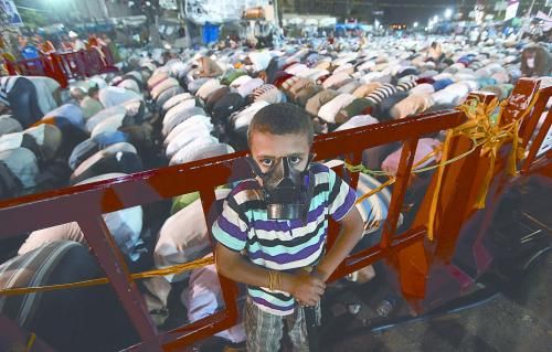 當?shù)貢r間28日晚，在埃及開羅納賽爾城，一名小男孩頭戴防毒面具參加穆兄會的集會示威。