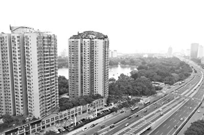 昨日，人濟(jì)山莊小區(qū)，與其他樓相比，B棟樓頂層天臺上違規(guī)建造了一棟兩層小樓，假山大樹俱全。新京報(bào)記者