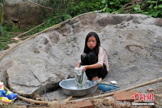 8月9日，云南巧家紅石巖村，10歲的劉鑫蕊在洗自己的衣服