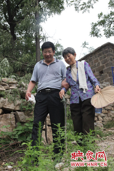 海付恒攙著患有腿部風濕性關節(jié)炎的劉梅英下山
