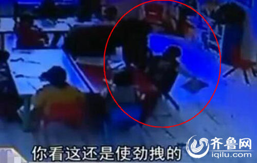 孩子上課時(shí)被老師拖拽。（紅圈中拿書者系孩子）