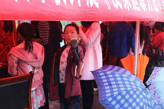 因為雨下的太大，小男孩玩起了接水游戲。