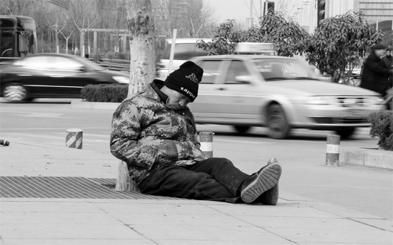 2月2日，鄭州市中州大道農(nóng)業(yè)路立交橋下，50歲的王文德打算在臨近春節(jié)前再接些零活兒，由于疲憊，他睡著