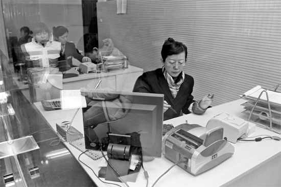 2月16日，鄭州市自來水總公司鄭東新區(qū)一營業(yè)廳，柜臺內(nèi)工作人員正在為市民辦理業(yè)務(wù)