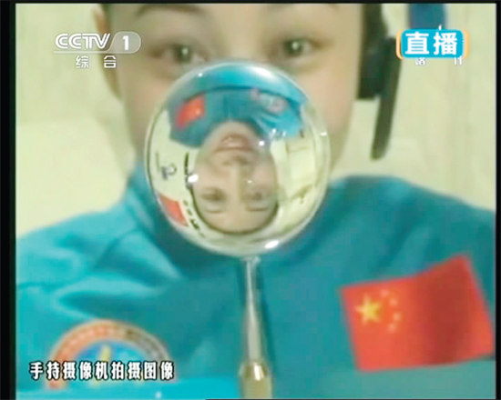 王亞平的倒影出現(xiàn)在水球中。新華社發(fā)（視頻截圖）