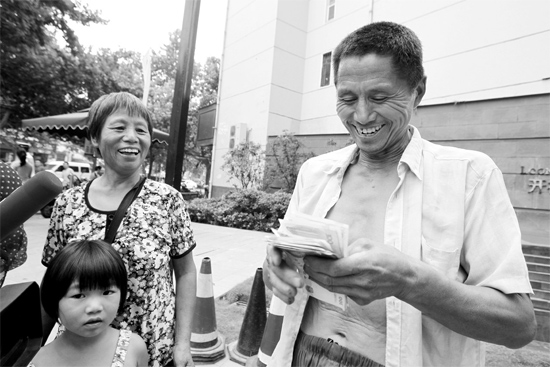 昨日，鄭州市明達(dá)路與豐慶路交叉口西300米路南，來自中牟的瓜農(nóng)拿到西瓜款，笑開顏東方今報(bào)記者袁曉強(qiáng)