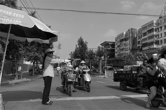 昨日，開封市區(qū)一名協(xié)管員在指揮群眾過(guò)馬路