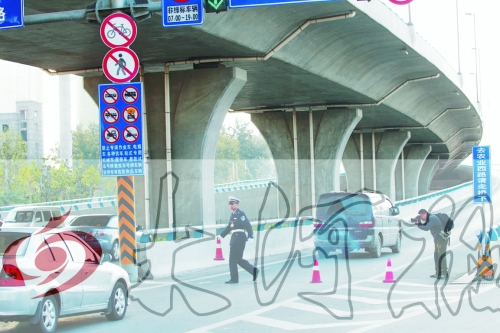 交警在東風(fēng)路從北向南上橋口處擺上反光錐，間歇放行
