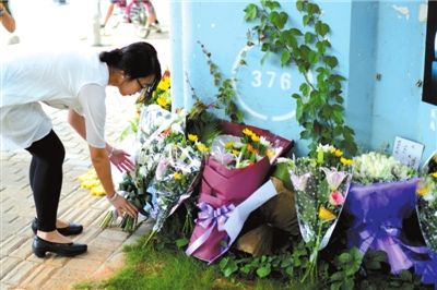 6月8日下午，記者來到廈門公交車爆炸事發(fā)現(xiàn)場橋下，附近已聚集了十幾個自發(fā)前來悼念的市民。橋墩下排放了一圈或黃或白的菊花，還有玖瑰、百合等。