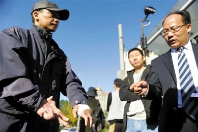 常林鋒在法院外展示雙手，他稱被燙傷的手因刑訊逼供且未得到及時(shí)救治