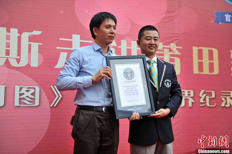 圖為世界吉尼斯認(rèn)證官為鄭春輝（左）頒發(fā)證書(shū)。呂明 攝